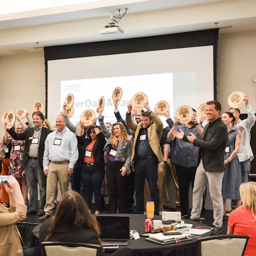 Law firm leaders raising their EverOak awards at an industry event